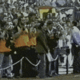 a group of people standing on a field with one wearing an orange vest that says ' a '