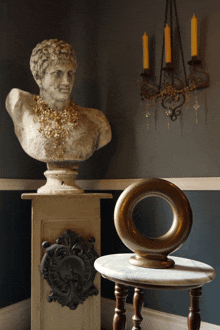 a statue of a man with a gold necklace is on a pedestal