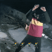 a person in a red yellow and black striped shirt is dancing