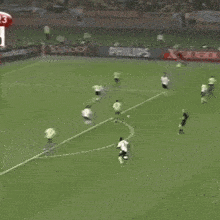 a soccer game is being played on a field with advertisements on the walls