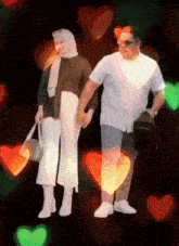 a man and a woman are holding hands in front of hearts