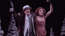 a man and woman are standing next to each other on a stage .