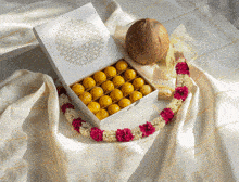 a box of yellow balls is sitting on a table next to a coconut