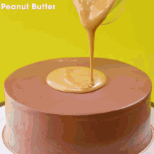 a person is using a spatula to spread a yellow sauce on a chocolate cake