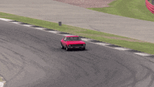 a red car is driving on a track with a green stripe on the side