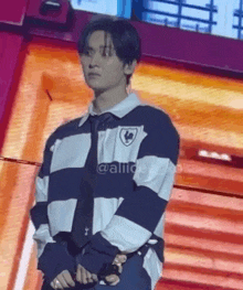 a man is standing on a stage wearing a striped shirt and tie .
