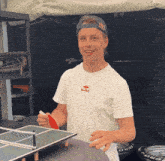 a man wearing a red bull t-shirt is holding a paddle