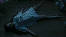 a woman laying on the floor wearing a t-shirt that says ' columbia ' on it