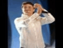a blurry picture of a man in a white shirt holding a knife in his hand .