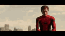 a man in a spider-man costume is standing in front of a city skyline .