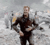 a man in a brown leather jacket is walking through a field .
