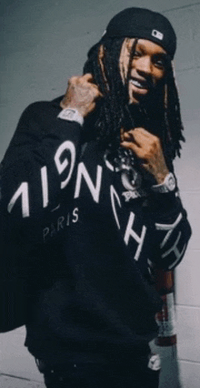 a man with dreadlocks is wearing a black sweatshirt that says paris