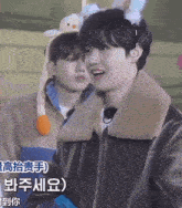 a man wearing a bunny ear headband stands next to another man wearing a leather jacket