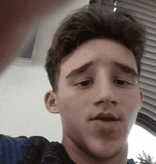 a close up of a young man 's face with a sad look on his face