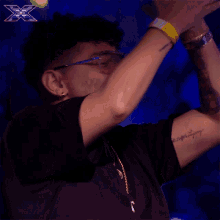 a man wearing glasses and a gold necklace says yeah