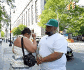 a man and a woman are standing on a sidewalk holding hands