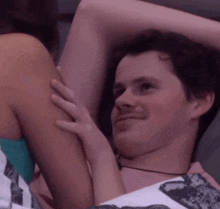 a man is laying on a bed with a woman holding his arm