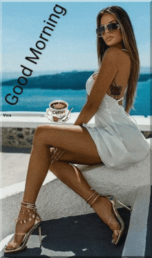 a woman in a white dress is sitting on a wall with a cup of coffee
