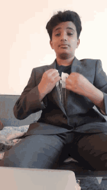 a man in a suit is adjusting his jacket