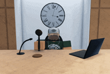a man sitting at a desk with a microphone and a clock above his head