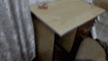 a blurred image of a wooden table with a red object on it