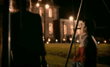 a man and a woman are standing next to each other in front of a house