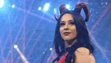 a woman with horns on her head looks at the camera .