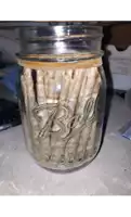 a mason jar filled with a bunch of cigarette wrappers