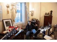 a man sits in a chair with his feet up in front of a desk