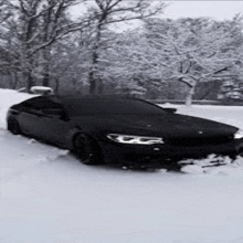 a black car is parked in the snow in a parking lot .