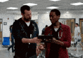 a man and a woman are looking at a tablet in a hospital hallway with the number 9 in the corner