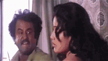 a man and a woman are standing next to each other in front of a mirror .