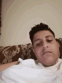 a man wearing headphones is laying on a couch