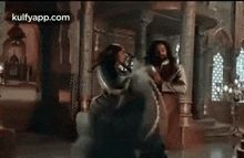 a couple of women are dancing in a room in a ballroom .