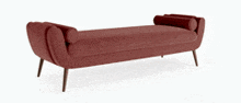a red bench with wooden legs and pillows on it