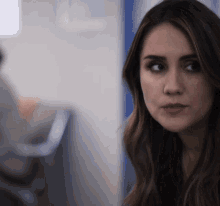 a close up of a woman 's face with a blue door in the background