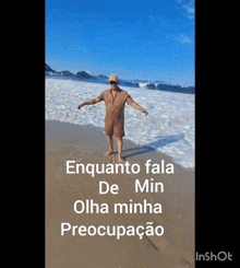 a man standing on a beach with his arms outstretched