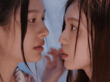 two women looking at each other 's faces with their tongues out