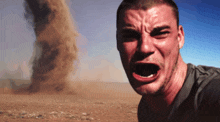 a man is crying in front of a sandstorm