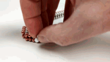 a close up of a person 's hand holding a bunch of beads .