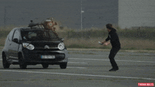 a man stands in front of a car with a license plate that says dd 161 ta
