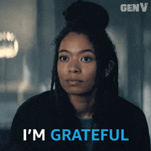 a woman with dreadlocks says i 'm grateful in blue letters