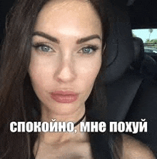 a close up of a woman 's face in a car with a meme in russian .