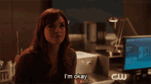 a woman says i 'm okay in front of a cw logo