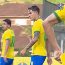 a group of soccer players are standing on a field . one of the players has a tattoo on his arm .