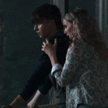 a man and a woman are standing next to each other and the woman is wearing a floral shirt