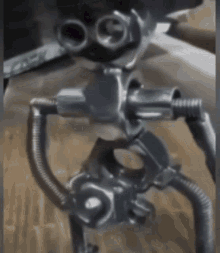 a close up of a metal robot with a hose attached to it 's legs