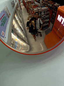a couple taking a picture of themselves in a store with a sign that says mt