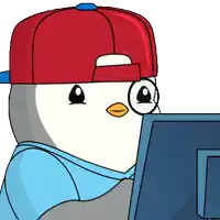 a penguin wearing a red hat and glasses is looking at a computer monitor