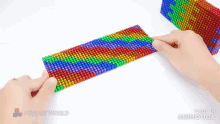 a person is playing with a rainbow colored toy that is made in animatica